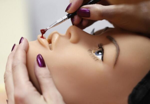 Рафаэла, одна из сотрудниц компании, работает над макияжем одной из кукол.
